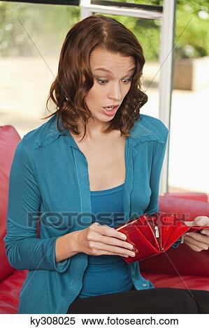 Young woman looking surprised while opening purse View Large Photo Image Stock Photography - Young woman looking surprised while opening purse. Fotosearch