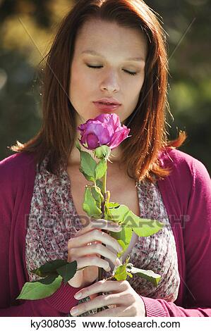 Stock Photography - Young woman smelling rose. Fotosearch
