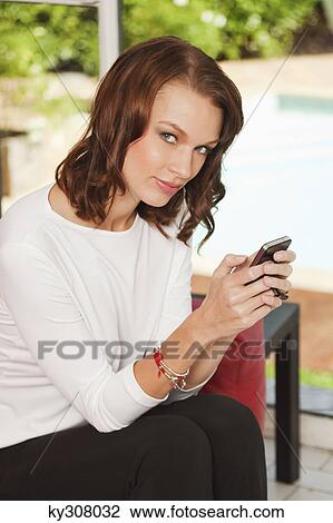 Young woman using iPhone View Large Photo Image Stock Image - Young woman using iPhone. Fotosearch