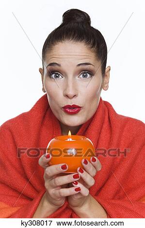 Young woman wrapped in blanket, holding candle View Large Photo Image Stock Photo - Young woman wrapped in blanket, holding candle. Fotosearch