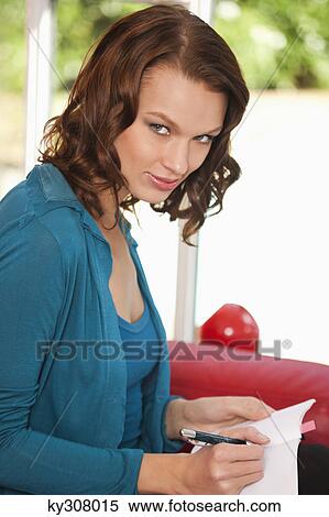 Young woman writing in notebook View Large Photo Image Stock Photography - Young woman writing in notebook. Fotosearch