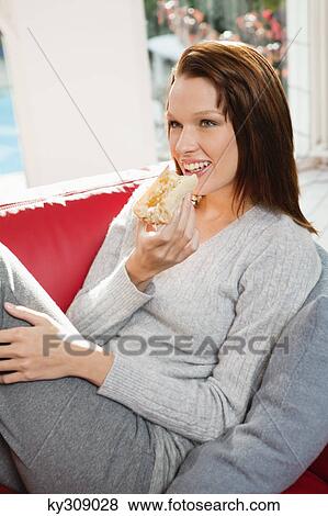 Young woman eating slice of bread View Large Photo Image Stock Photo - Young woman eating slice of bread. Fotosearch