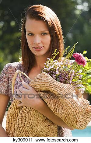 Young woman holding bouquet View Large Photo Image Stock Image - Young woman holding bouquet. Fotosearch