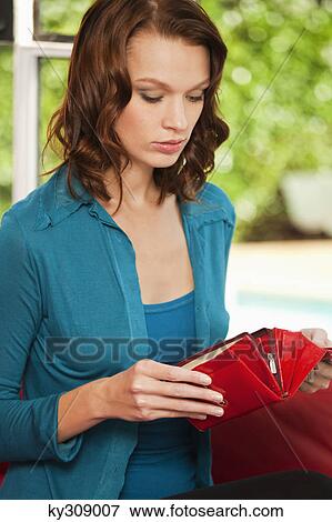 Stock Photo - Young woman opening purse. Fotosearch