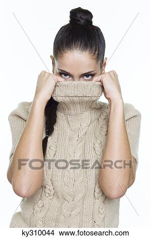 Picture - Young woman covering her face with sweater. Fotosearch
