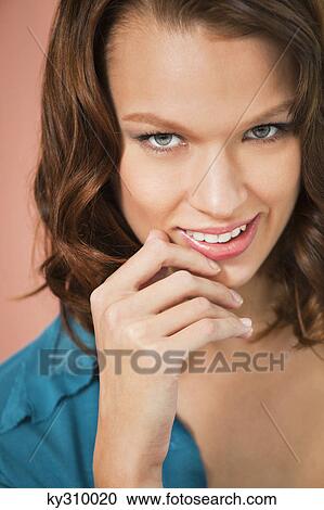 Stock Image - Young woman smiling at camera. Fotosearch