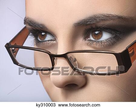 Stock Image - Young woman wearing eyeglasses. Fotosearch