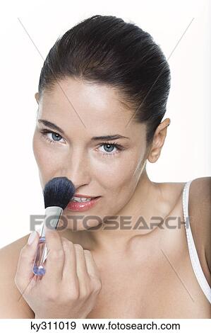 Young woman applying blush View Large Photo Image Stock Photo - Young woman applying blush. Fotosearch