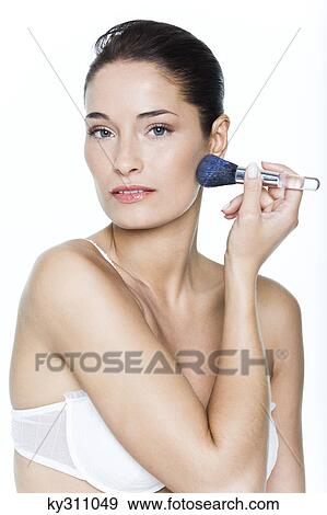 Young woman applying blush View Large Photo Image Stock Photo - Young woman applying blush. Fotosearch