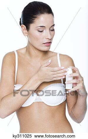 Stock Photography - Young woman applying moisturizer. Fotosearch