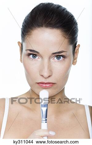 Picture - Young woman holding make-up brush. Fotosearch