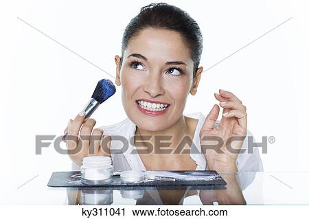 Young woman holding make-up brush View Large Photo Image Stock Image - Young woman holding make-up brush. Fotosearch
