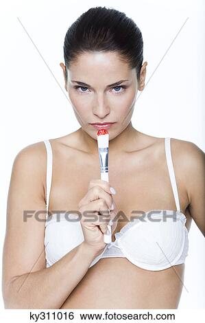 Young woman holding make-up brush View Large Photo Image Stock Photograph - Young woman holding make-up brush. Fotosearch