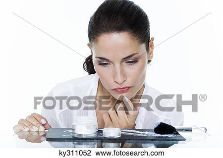 Young woman looking at cosmetics display View Large Photo Image Stock Image - Young woman looking at cosmetics display. Fotosearch