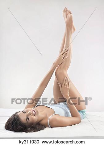 Young woman rubbing leg View Large Photo Image Stock Image - Young woman rubbing leg. Fotosearch