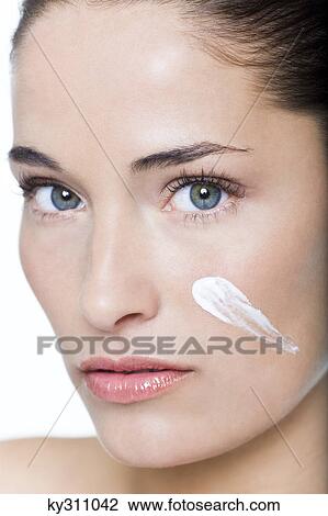 Young woman with moisturizer on her cheek View Large Photo Image Stock Image - Young woman with moisturizer on her cheek. Fotosearch