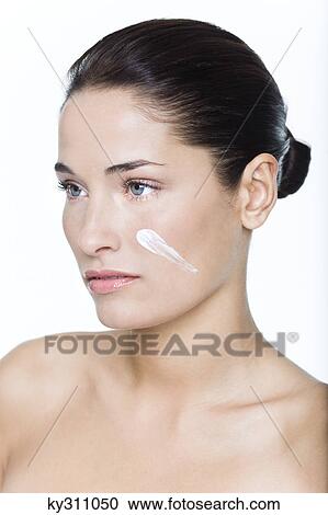 Young woman with moisturizer on her cheek View Large Photo Image Stock Image - Young woman with moisturizer on her cheek. Fotosearch