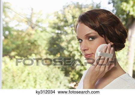 Young woman applying face powder View Large Photo Image Picture - Young woman applying face powder. Fotosearch