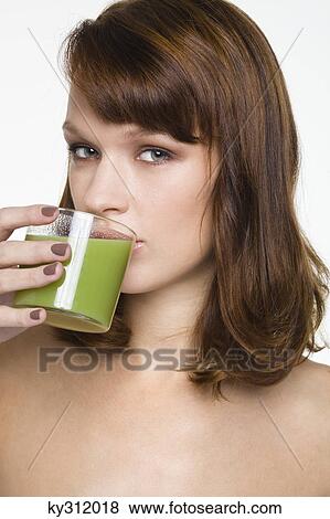 Young woman drinking glass of wheatgrass juice View Large Photo Image Stock Photo - Young woman drinking glass of wheatgrass juice. Fotosearch