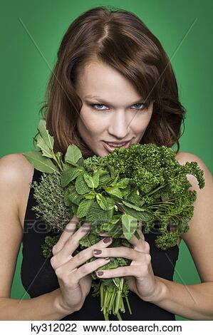 Young woman holding fresh herbs View Large Photo Image Stock Image - Young woman holding fresh herbs. Fotosearch