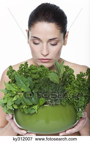 Young woman holding fresh herbs View Large Photo Image Stock Photo - Young woman holding fresh herbs. Fotosearch