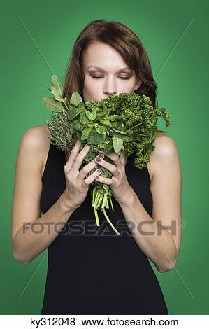 Young woman holding fresh herbs View Large Photo Image Stock Photo - Young woman holding fresh herbs. Fotosearch