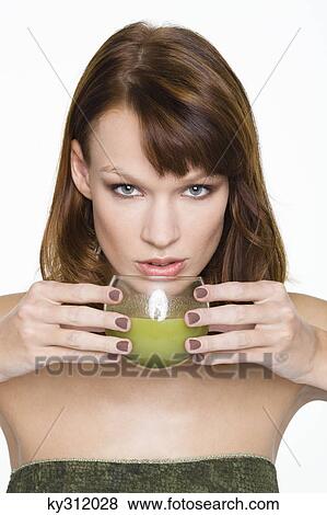 Young woman holding glass of wheatgrass juice View Large Photo Image Stock Photo - Young woman holding glass of wheatgrass juice. Fotosearch
