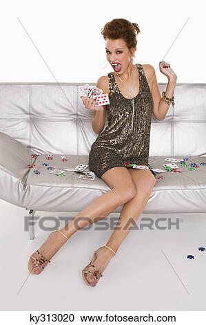 Stock Image - Young happy woman in formalwear holding cards. Fotosearch