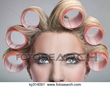 Stock Image - Young woman in curlers. Fotosearch