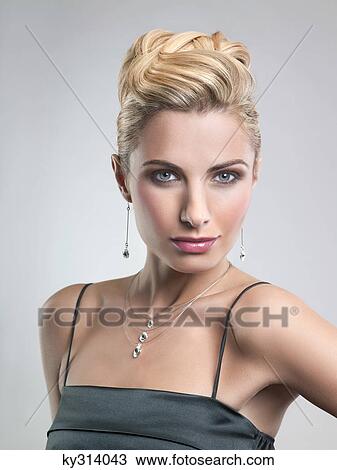 Young woman in formalwear looking at camera View Large Photo Image Stock Image - Young woman in formalwear looking at camera. Fotosearch