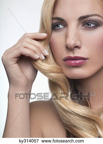 Young woman touching her hair View Large Photo Image Stock Photo - Young woman touching her hair. Fotosearch