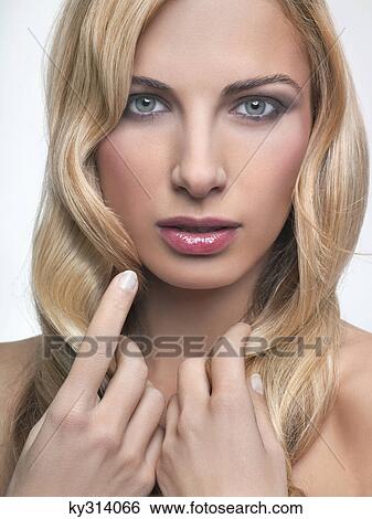 Young woman touching her hair View Large Photo Image Stock Photograph - Young woman touching her hair. Fotosearch