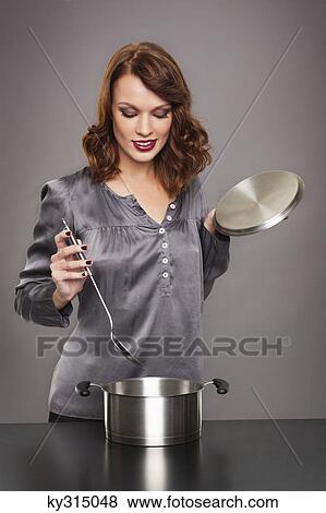 Young woman cooking View Large Photo Image Stock Photo - Young woman cooking. Fotosearch