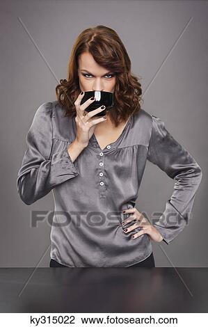 Stock Image - Young woman drinking coffee. Fotosearch