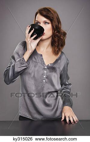 Stock Photograph - Young woman drinking coffee. Fotosearch