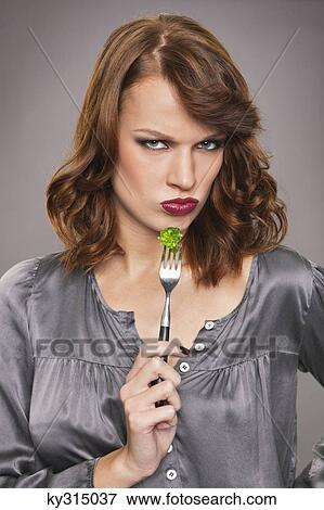 Young woman eating broccoli View Large Photo Image Stock Photo - Young woman eating broccoli. Fotosearch