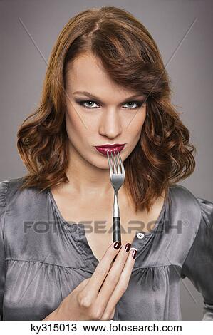 Young woman holding fork View Large Photo Image Stock Image - Young woman holding fork. Fotosearch