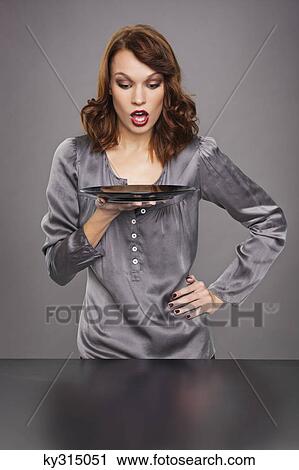 Stock Image - Young woman holding plate. Fotosearch