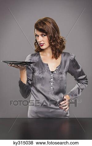 Stock Photo - Young woman holding plate. Fotosearch
