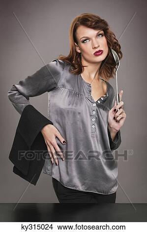 Picture - Young woman holding spoon and napkin. Fotosearch