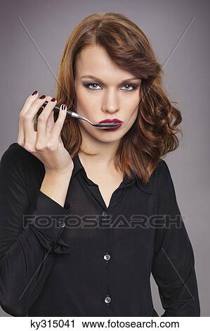 Stock Image - Young woman holding spoon. Fotosearch