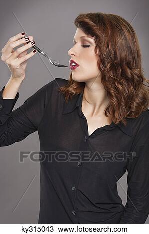 Young woman holding spoon View Large Photo Image Stock Image - Young woman holding spoon. Fotosearch