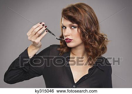 Young woman holding spoon View Large Photo Image Stock Photograph - Young woman holding spoon. Fotosearch