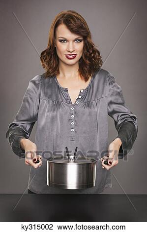 Young woman holding stew pot View Large Photo Image Stock Image - Young woman holding stew pot. Fotosearch