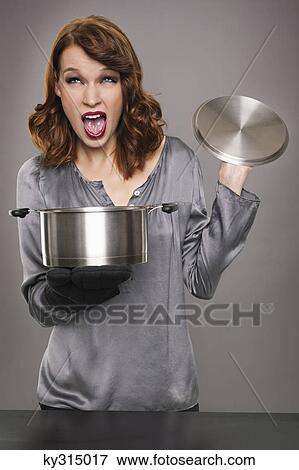 Young woman looking at content of stew pot View Large Photo Image Stock Photo - Young woman looking at content of stew pot. Fotosearch