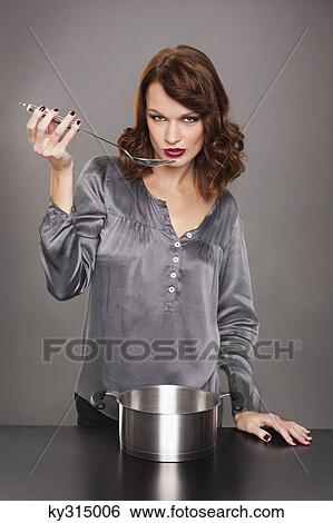 Stock Photograph - Young woman tasting food. Fotosearch