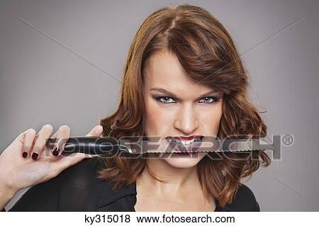 Young woman with knife between teeth View Large Photo Image Stock Photo - Young woman with knife between teeth. Fotosearch