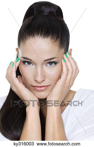 Stock Image - Portrait of young woman with hands on chin. Fotosearch