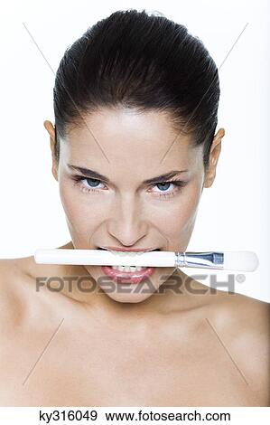 Young woman biting make-up brush View Large Photo Image Stock Photo - Young woman biting make-up brush. Fotosearch
