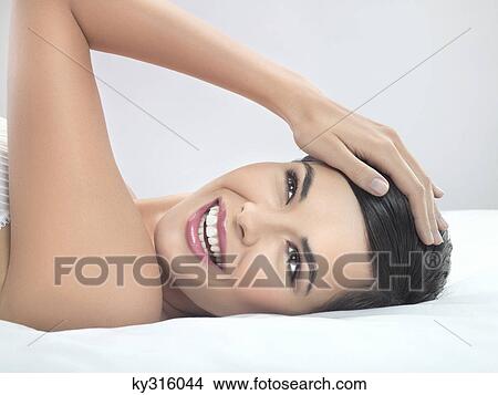 Picture - Young woman lying on back. Fotosearch